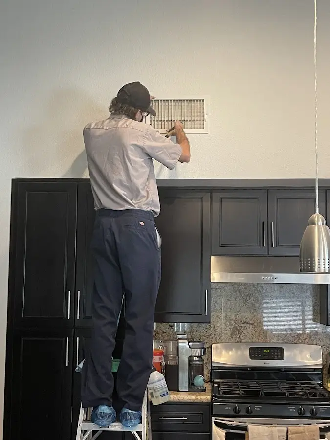 Technician inspecting an air vent during HVAC service in Lititz
